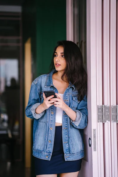 Güzel, uzun boylu, zarif ve genç Hintli Asyalı kadın manifatura onun akıllı portresi. O bir retro Kot ceket giyiyor 