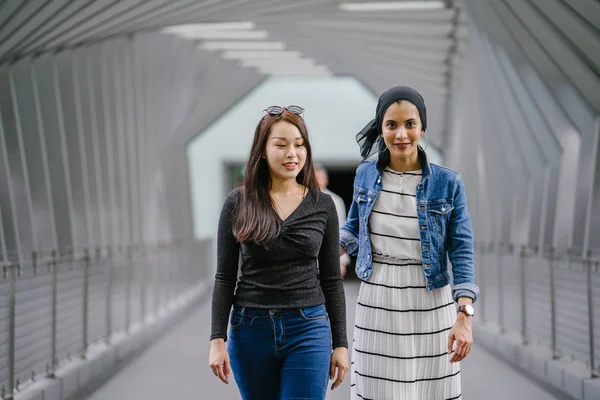 Gündüz vakti köprüde farklı etnik kökenlere sahip iki arkadaş. Biri Malezyalı Müslüman bir kadın, diğeri de Çinli bir Asyalı. İkisi de genç, enerjik ve çekici..