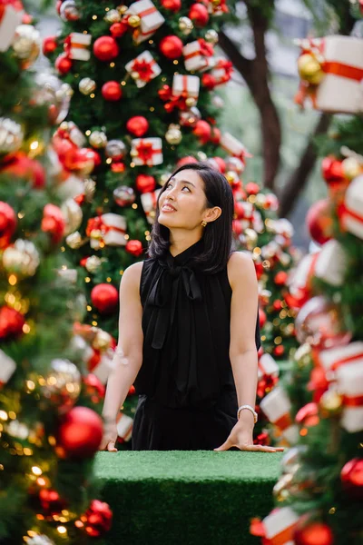 Güzel ve genç bir Kore Asya kadın portresi beholds ve harikası Noel süsleri smiling