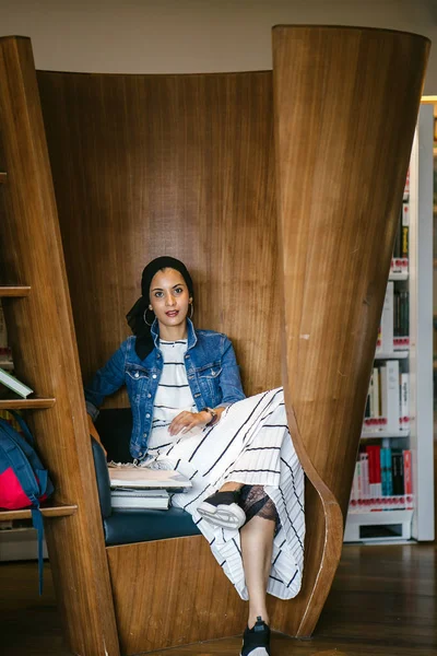 Genç, uzun boylu, zayıf, çekici ve güzel Malezyalı Müslüman kadın kütüphanede oturmuş kitap okuyor. Çalışıyor ve tek başına araştırma yapıyor..