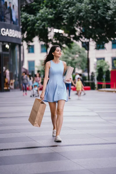 ファッショナブルな幸せな若いアジアのインドの女性商店街の通りを歩いて青いドレス — ストック写真