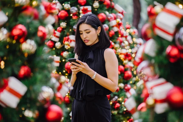 Güzel ve genç bir Kore Asya kadın portresi beholds ve harikası Noel süsleri smiling