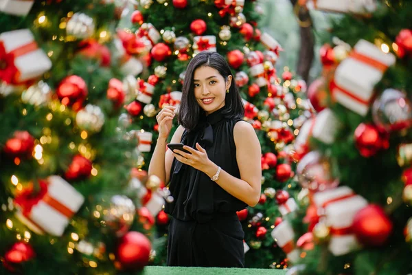 Güzel ve genç bir Kore Asya kadın portresi beholds ve harikası Noel süsleri smiling