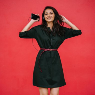 Bir güzel, Genç ve çekici Hint Asyalı kadın bir yeşil elbise ve kırmızı bir arka plan kırmızı kemer Studio portresi