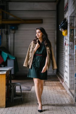 Hint Asyalı kadın Genç, uzun boylu, ince ve zarif bir portre için poz veriyor. O rahat ve şık rahat giysiler giyiyor ve bir adamın ceketi omuzları üzerinde bol dökümlü vardır. 