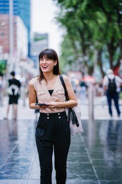 Onun smartphone kullanarak Genç, çekici Çinli Asyalı kadın