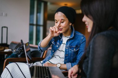 Müslüman bir Orta Doğulu kadın Çinli bir meslektaşıyla iş görüşmesi yapıyor..