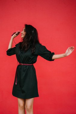 Bir güzel, Genç ve çekici Hint Asyalı kadın bir yeşil elbise ve kırmızı bir arka plan kırmızı kemer Studio portresi