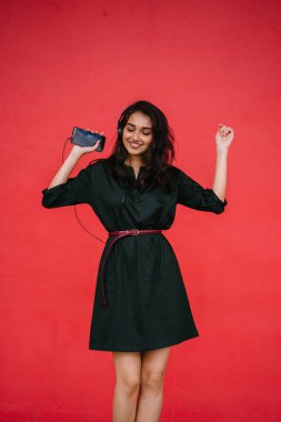 Bir güzel, Genç ve çekici Hint Asyalı kadın bir yeşil elbise ve kırmızı bir arka plan kırmızı kemer Studio portresi