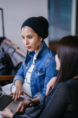 Müslüman bir Orta Doğulu kadın Çinli bir meslektaşıyla iş görüşmesi yapıyor..