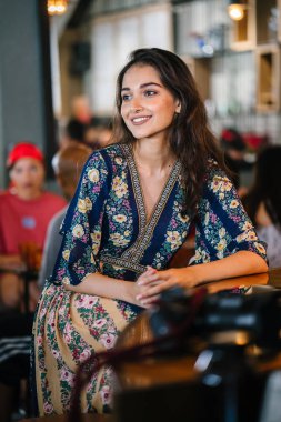 portre baş shot, kendine güvenen, Genç ve çekici Hint Asya kız sıcak aydınlatılmış bir trendy Cafe