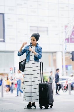 Genç, uzun, ince ve zarif bir Malezyalı Müslüman 'ın portresi şehrin kalabalık bir caddesinde duruyor..