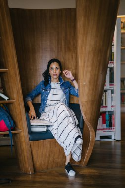 Genç, zarif ve çekici Malezyalı Müslüman kadın gün boyunca elbise ve kot ceket giyiyor..