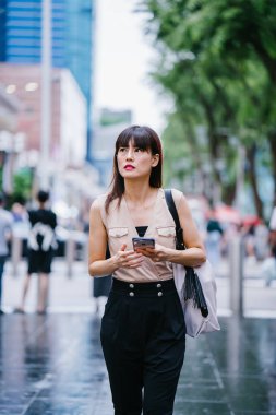 Onun smartphone kullanarak Genç, çekici Çinli Asyalı kadın