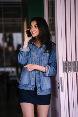 Onun Smartphone'da bahseden bir güzel, uzun boylu, zarif ve genç Hintli Asyalı kadın portresi. O bir retro Kot ceket giyiyor 