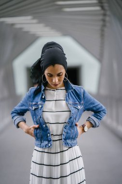 Genç, zarif ve çekici Malezyalı Müslüman kadın gün boyunca elbise ve kot ceket giyiyor..