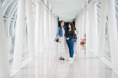Gündüz vakti köprüde farklı etnik kökenlere sahip iki arkadaş. Biri Malezyalı Müslüman bir kadın, diğeri de Çinli bir Asyalı. İkisi de genç, enerjik ve çekici..