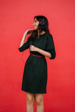 Bir güzel, Genç ve çekici Hint Asyalı kadın bir yeşil elbise ve kırmızı bir arka plan kırmızı kemer Studio portresi