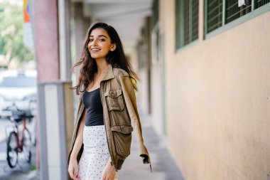 Gün boyunca bir geçit Asya'da bir şehirde yürürken bir uzun boylu, güzel, ince ve zarif Hint Asyalı kadın portresi. O zarif giyindi ve bir ceket omuzları üzerinde bol dökümlü vardır.