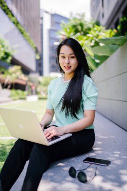 Genç ve çekici bir Asyalı kadın öğrenci oturur ve gün boyunca bir üniversite kampüsünde onu dizüstü bilgisayar üzerinde çalışır. O, o çalışırken gelişigüzel giyinmiş. 