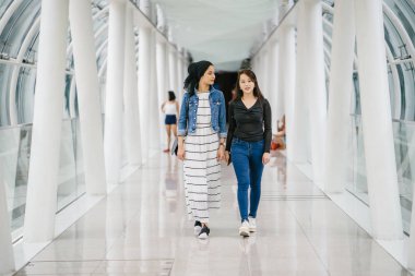 Gündüz vakti köprüde farklı etnik kökenlere sahip iki arkadaş. Biri Malezyalı Müslüman bir kadın, diğeri de Çinli bir Asyalı. İkisi de genç, enerjik ve çekici..