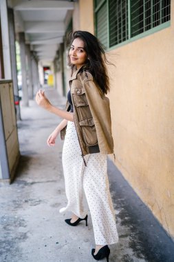 Gün boyunca bir geçit Asya'da bir şehirde yürürken bir uzun boylu, güzel, ince ve zarif Hint Asyalı kadın portresi. O zarif giyindi ve bir ceket omuzları üzerinde bol dökümlü vardır.