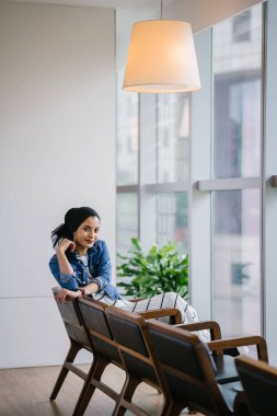 Genç, zarif ve çekici Malezyalı Müslüman kadın gün boyunca elbise ve kot ceket giyiyor..