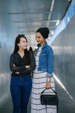 Gündüz vakti köprüde farklı etnik kökenlere sahip iki arkadaş. Biri Malezyalı Müslüman bir kadın, diğeri de Çinli bir Asyalı. İkisi de genç, enerjik ve çekici..