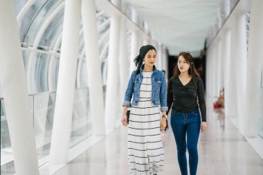 Gündüz vakti köprüde farklı etnik kökenlere sahip iki arkadaş. Biri Malezyalı Müslüman bir kadın, diğeri de Çinli bir Asyalı. İkisi de genç, enerjik ve çekici..