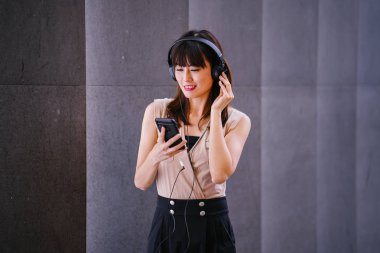 Onun kulaklık müzik dinlemek orta yaşlı, fotojenik bir Çinli kadın portresi