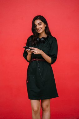 Bir güzel, Genç ve çekici Hint Asyalı kadın bir yeşil elbise ve kırmızı bir arka plan kırmızı kemer Studio portresi