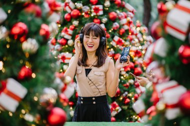 Gün boyunca birkaç süslü Noel ağaçları arasında duran zarif ve çekici bir orta yaşlı kadın portresi