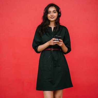 Bir güzel, Genç ve çekici Hint Asyalı kadın bir yeşil elbise ve kırmızı bir arka plan kırmızı kemer Studio portresi