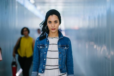 Genç, zarif ve çekici Malezyalı Müslüman kadın gün boyunca elbise ve kot ceket giyiyor..