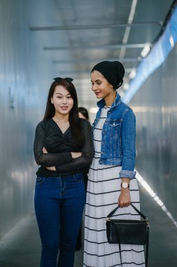 Gündüz vakti köprüde farklı etnik kökenlere sahip iki arkadaş. Biri Malezyalı Müslüman bir kadın, diğeri de Çinli bir Asyalı. İkisi de genç, enerjik ve çekici..
