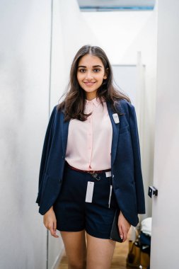 Yeni giyim moda salonu bir alışveriş merkezinde bir montaj odasında çalışıyor bir genç ve güzel Hint Asyalı kadın portresi.