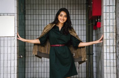 Hint Asyalı kadın Genç, uzun boylu, ince ve zarif bir portre için poz veriyor. O rahat ve şık rahat giysiler giyiyor ve bir adamın ceketi omuzları üzerinde bol dökümlü vardır. 