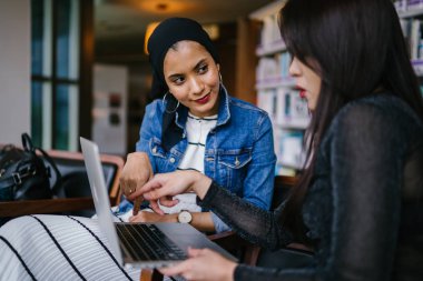 Müslüman bir Orta Doğulu kadın Çinli bir meslektaşıyla iş görüşmesi yapıyor..