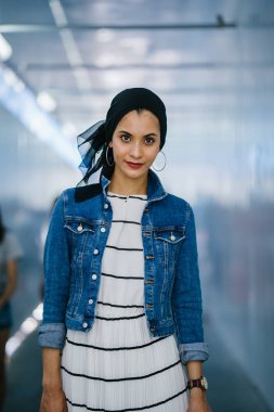 Genç, zarif ve çekici Malezyalı Müslüman kadın gün boyunca elbise ve kot ceket giyiyor..