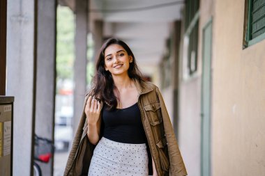 Gün boyunca bir geçit Asya'da bir şehirde yürürken bir uzun boylu, güzel, ince ve zarif Hint Asyalı kadın portresi. O zarif giyindi ve bir ceket omuzları üzerinde bol dökümlü vardır.