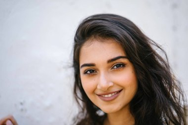 bir uzun boylu, Genç, zarif ve güzel Hint Asyalı kadın bir sokakta yıpranmış bir duvara portresi 