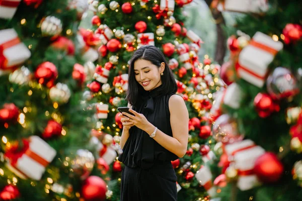 Güzel ve genç bir Kore Asya kadın portresi beholds ve harikası Noel süsleri smiling