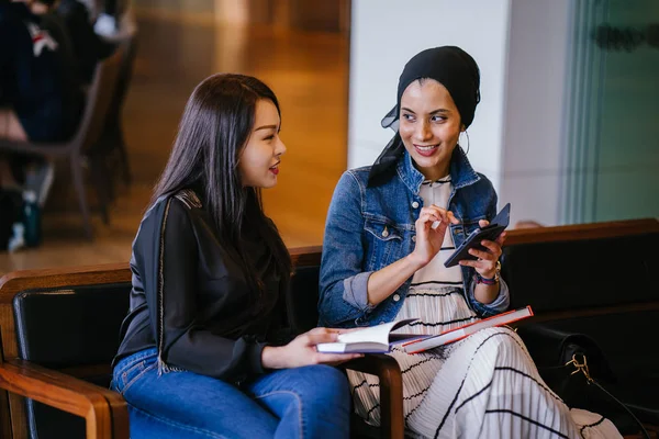 Две Молодые Подруги Сидят Скамейке Читают Книги Обсуждают Одна Мусульманка — стоковое фото