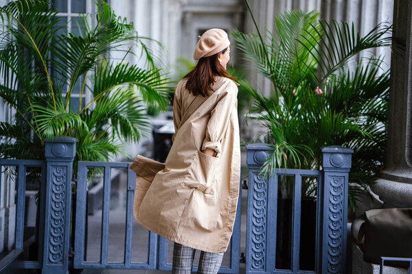 Портрет модной, элегантной и красивой азиатки средних лет. Она улыбается, когда позирует в сером коридоре здания суда.
.