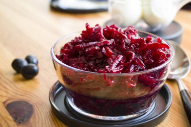 Hafif ahşap bir masa üzerinde bir tabakta haşlanmış pancar parçaları.