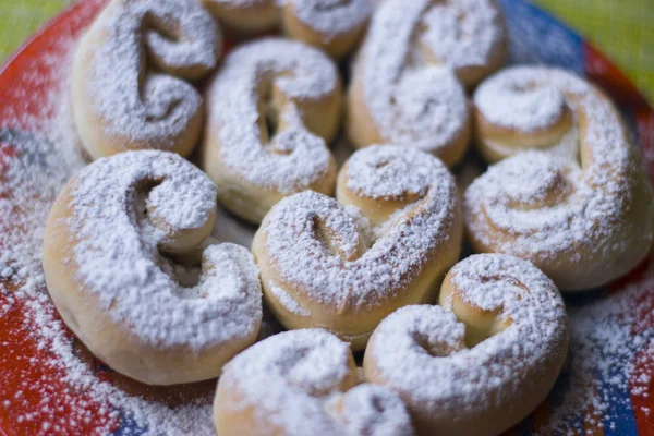 Kırmızı bir tepside pudra şekeri serpilir buns.