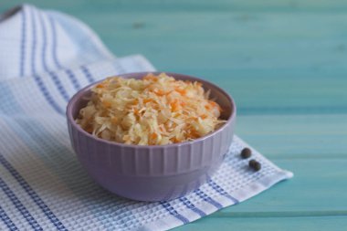 Fotoğraf parlak mavi renkli bir tabağa lahana ve havuç salatası.