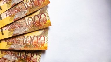 Kenya banknotları bir tarafta ve beyaz üzerinde sergileniyor. Kenya para birimi. Kopyalama uzayı bir tarafta. Mesaj için yer var. 1000 şilin nakit. Flatlay. Yukarıdan görüntüle.