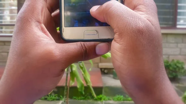 Mãos Jovem Segurando Smartphone Fora Seu Polegar Tocando Tela Que — Fotografia de Stock
