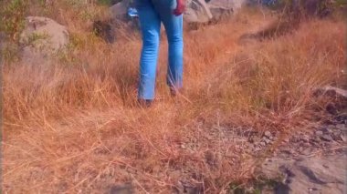 Yürüyüş yolunda tek başına yürüyen bir adam yavaşça yürürken bir şişe su taşıyor. Bir çimen teli koparıyor ve video klibine devam ediyor. Bacakları ve ayakkabıları kısmen görünüyor. Toprakta kayalar, taşlar ve kuru otlar var. Boş bir yürüyüş..